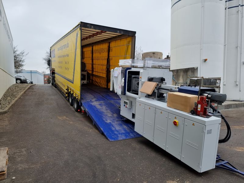 Eine Maschine wird auf einen LKW geladen.